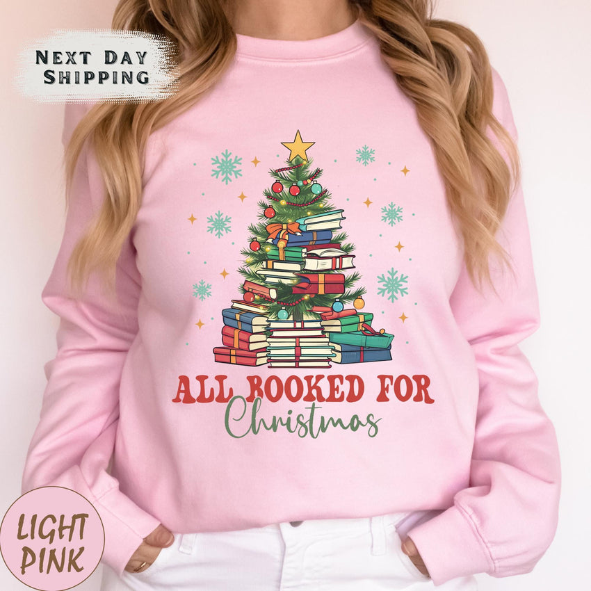 a woman wearing a pink sweatshirt with a christmas tree on it