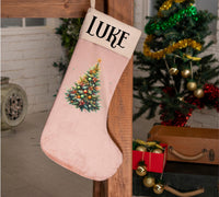 a pink christmas stocking with a tree on it