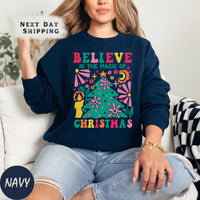 a woman sitting on a couch wearing a christmas sweater