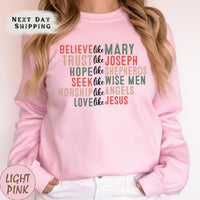 a woman wearing a pink sweatshirt that says, believe the mary trust the joseph hope