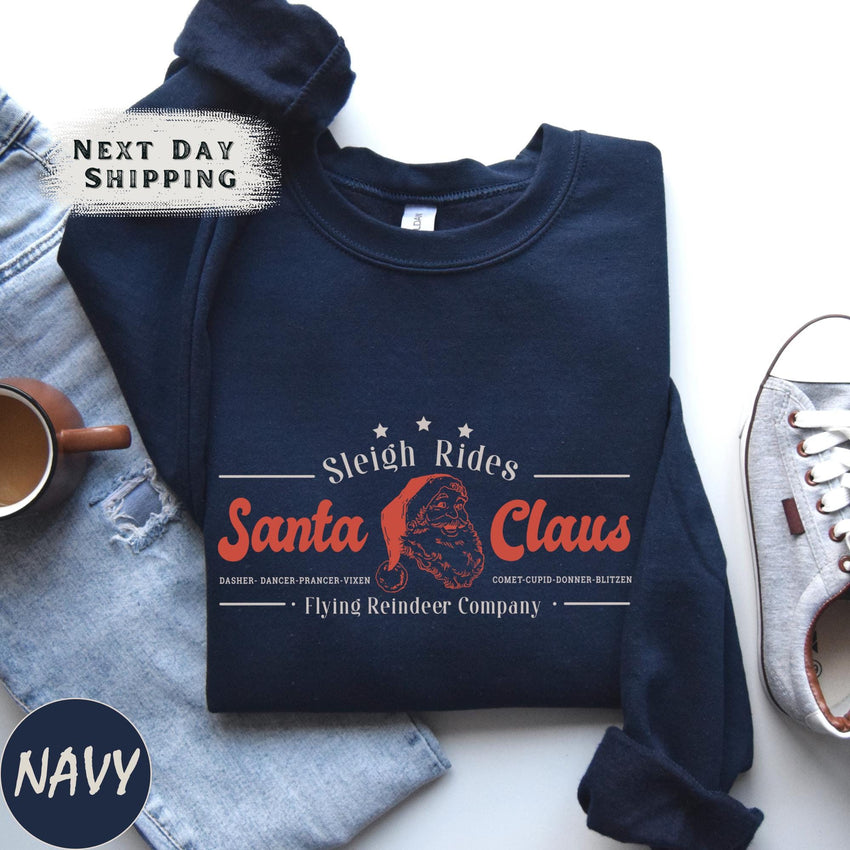 a t - shirt that says santa claus next to a pair of shoes