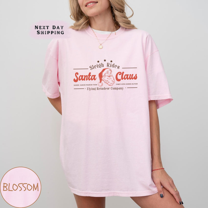 a woman wearing a pink santa clause t - shirt