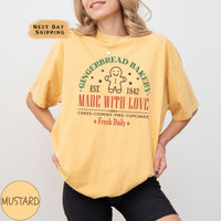 a woman wearing a mustard colored t - shirt with an image of a gingerbread