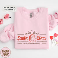 a pink sweatshirt with santa claus on it