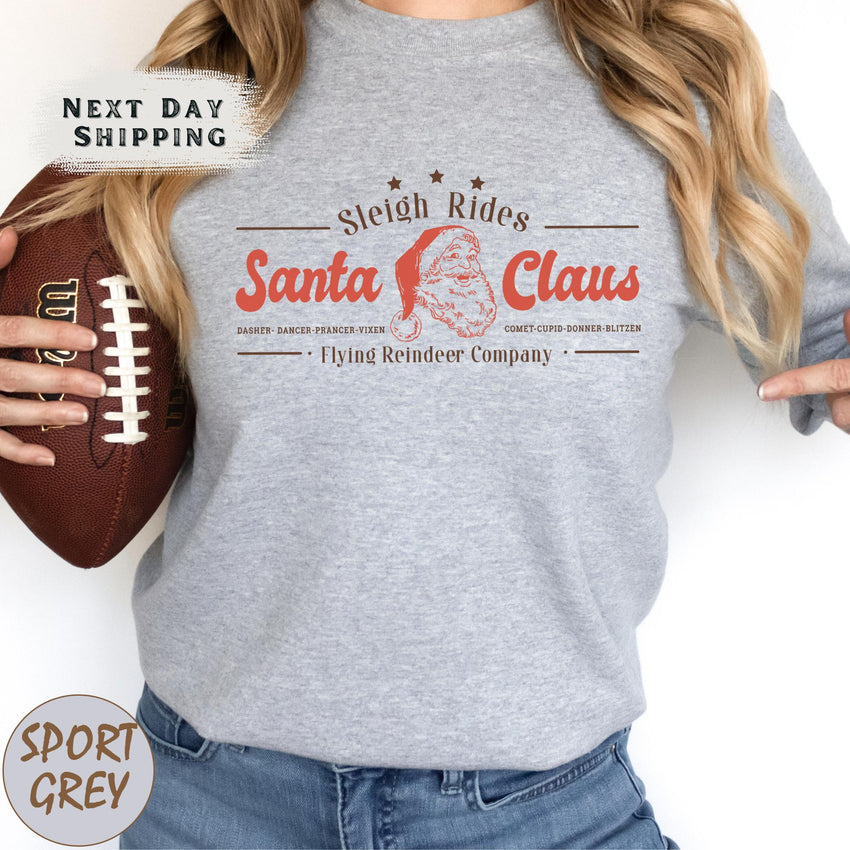 a woman holding a football and wearing a santa claus shirt