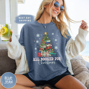 a woman sitting on a couch with a christmas tree on her shirt