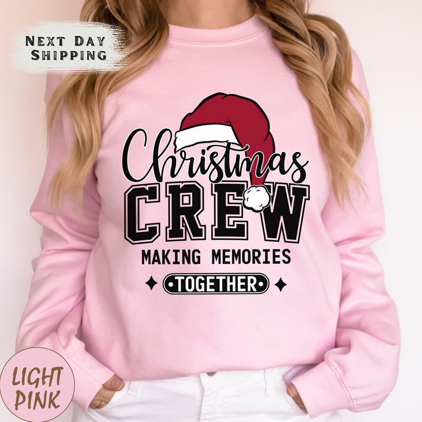 a woman wearing a pink christmas crew sweatshirt