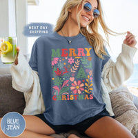 a woman sitting on a couch wearing a merry christmas shirt